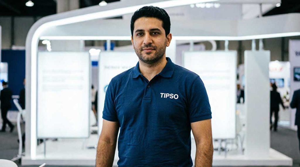 غرفهدار ایرانی با پولوشرت سرمهای و لوگوی TIPSO در نمایشگاه تجاری تهران